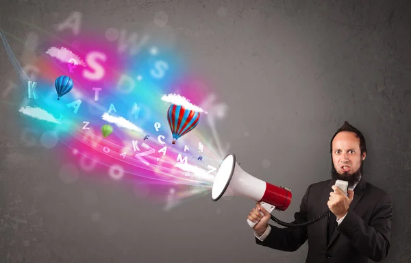 Man shouting into megaphone and abstract text and balloons come — Stock Photo, Image