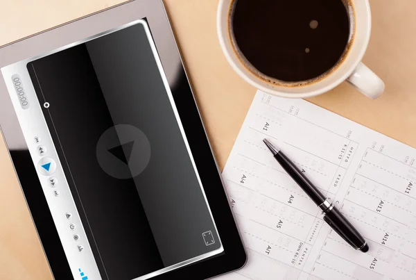 Tablet PC que muestra el reproductor multimedia en la pantalla con una taza de café en —  Fotos de Stock