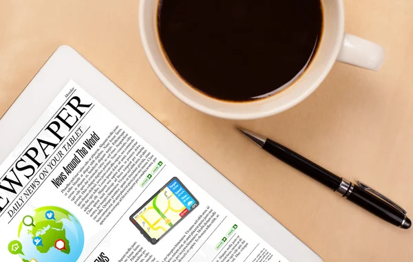 Tablet pc mostra notícias na tela com uma xícara de café em uma mesa — Fotografia de Stock