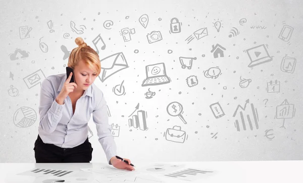 Business woman sitting at table with hand drawn media icons — Stock Photo, Image