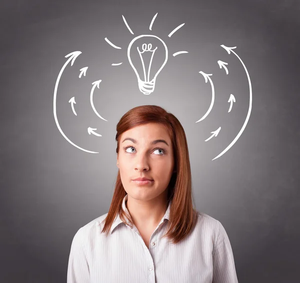 Pretty lady thinking with arrows and light bulb overhead — Stock Photo, Image