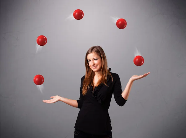 Joven chica de pie y malabarismo con bolas rojas —  Fotos de Stock