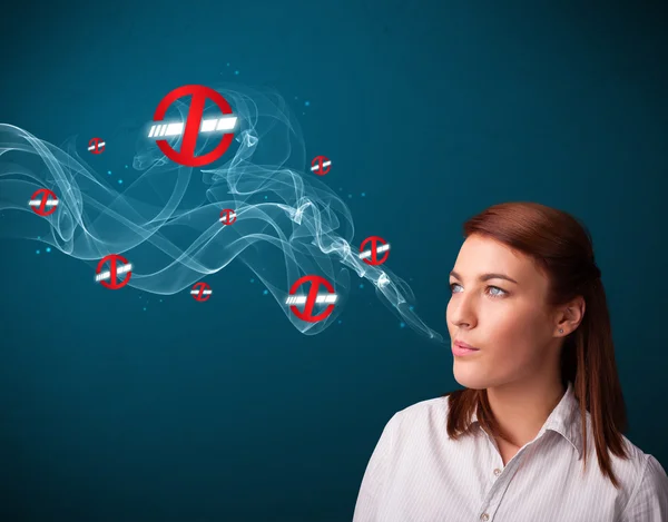 Young woman smoking dangerous cigarette with no smoking signs — Stock Photo, Image