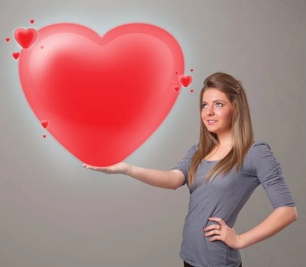 Young lady holding lovely 3d red heart — Stock Photo, Image