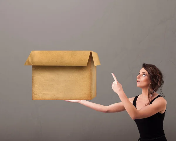 Jovem segurando uma caixa de papelão vazia — Fotografia de Stock