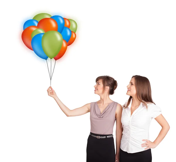 Mladé ženy drží barevné balónky — Stock fotografie
