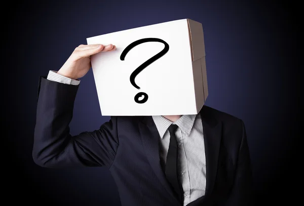 Zakenman gebaren met een kartonnen doos op zijn hoofd met vragen — Stockfoto
