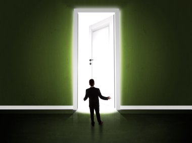 Büyük parlak kapıyı açan bir iş adamı.