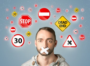 Ağzı ve trafik işaretleri olan genç bir adam.