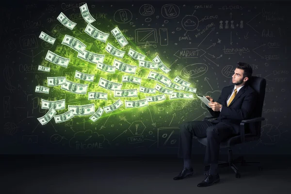 Businessman sitting in chair holding tablet with dollar bills co — Stock Photo, Image