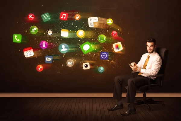 Homem de negócios sentado na cadeira do escritório com tablet e ap colorido — Fotografia de Stock