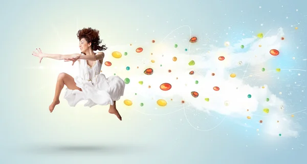 Beautiful woman jumping with colorful gems and crystals on the b — Stock Photo, Image