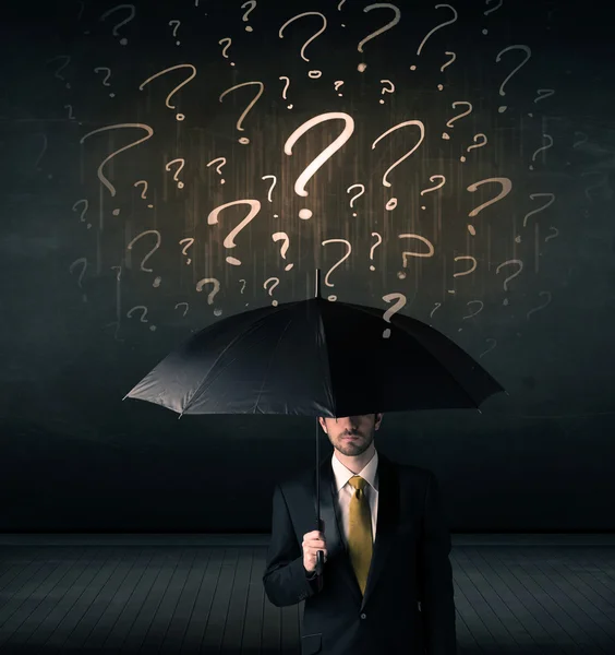 Бізнесмен з парасолькою і безліч намальованих знаків питання — стокове фото