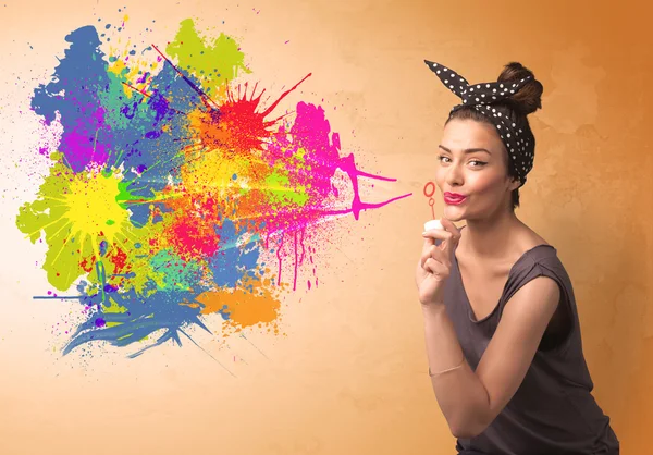 Cute girl blowing colorful splash graffiti — Stock Photo, Image