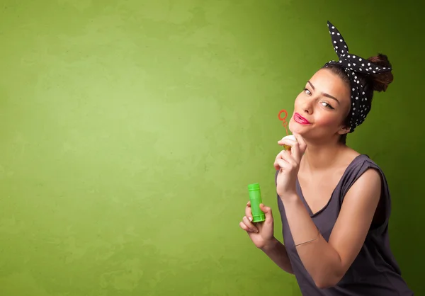 Hermosa mujer soplando burbuja de jabón sobre fondo de copyspace — Foto de Stock