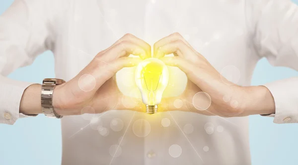 Hands creating a form with light bulb