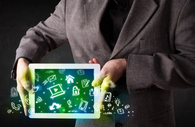 Yeşil ortam simgeleri ve sembolleri olan tablet tutan kişi