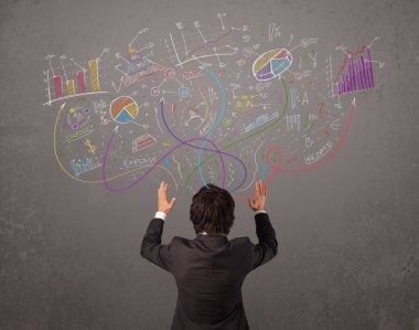 Genç iş adamı çizimlere ve sembollere bakıyor.