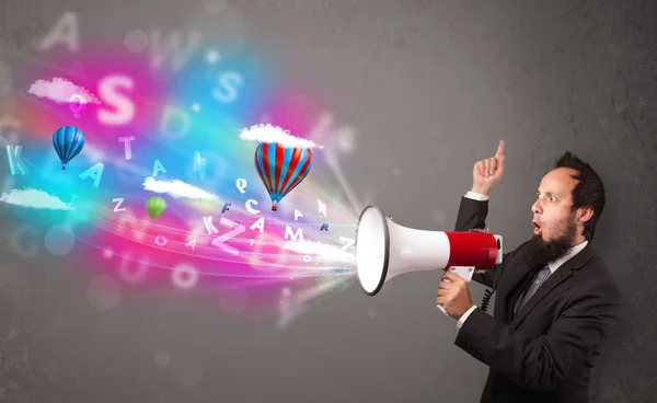 Man shouting into megaphone and abstract text and balloons come — Stock Photo, Image