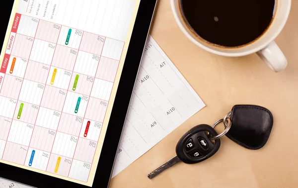 Tablet pc che mostra il calendario sullo schermo con una tazza di caffè su un d — Foto Stock