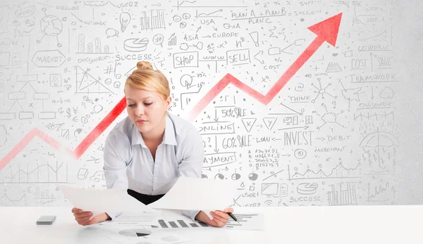 Femme d'affaires assise à table avec des diagrammes de marché — Photo