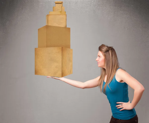 Jovencita sosteniendo un juego de cajas de cartón marrón — Foto de Stock