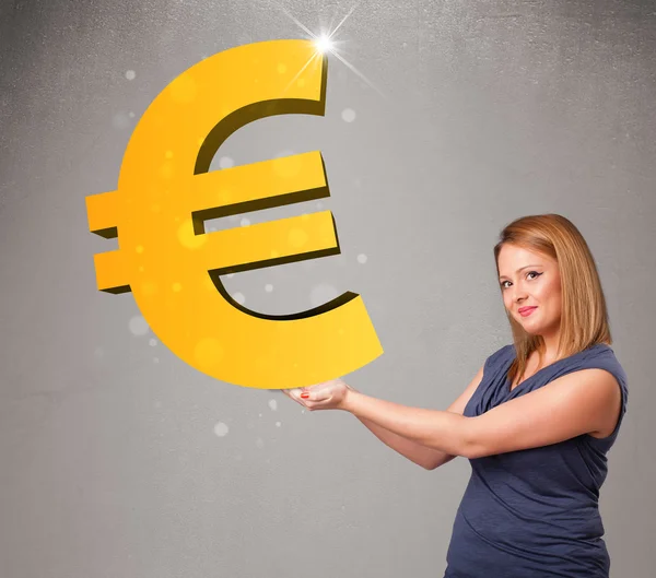 Beautiful girl holding a big 3d gold euro sign — Stock Photo, Image