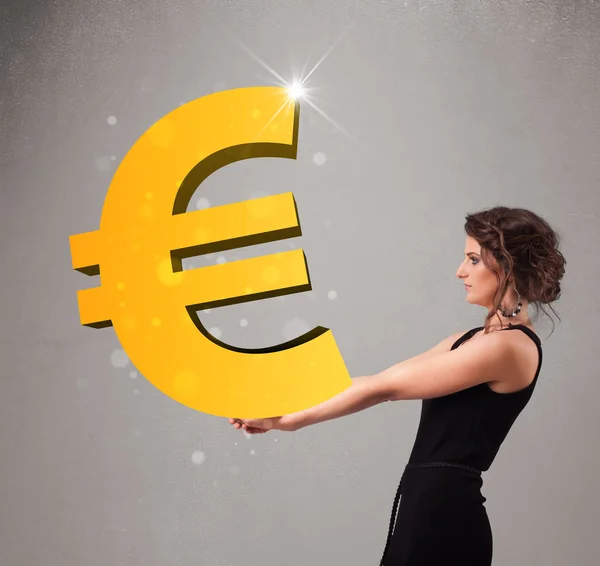 Beautiful girl holding a big 3d gold euro sign — Stock Photo, Image