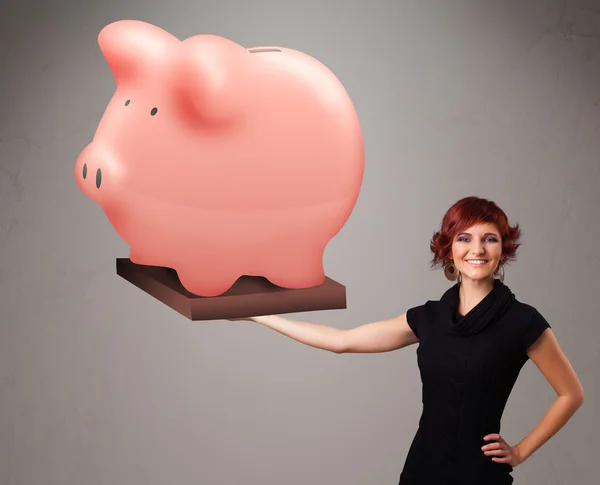 Jovem segurando uma enorme poupança porquinho banco — Fotografia de Stock