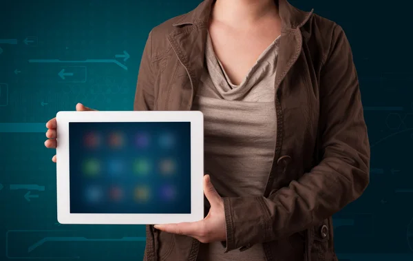 Frau hält weißes Tablet mit verschwommenen Apps in der Hand — Stockfoto
