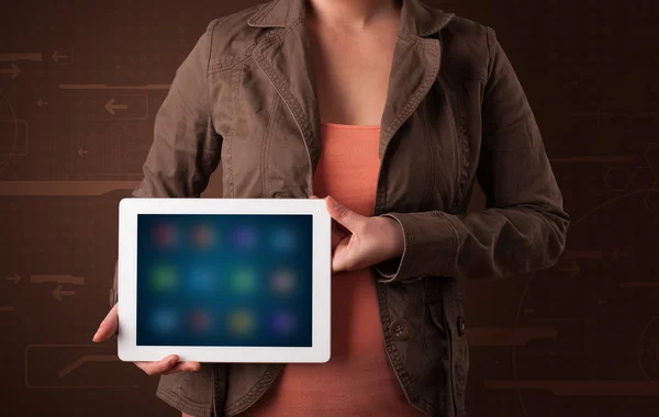 Frau hält weißes Tablet mit verschwommenen Apps in der Hand — Stockfoto