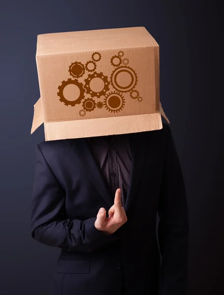 Young man gesturing with a cardboard box on his head with spur w — Stock Photo, Image