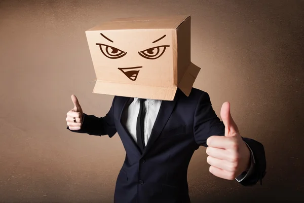 Businessman gesturing with a cardboard box on his head with evil — Stock Photo, Image