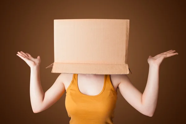 Menina gesticulando com uma caixa de papelão em sua cabeça — Fotografia de Stock