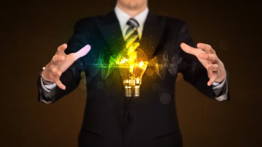 Elinde ampul tutan bir iş adamı.