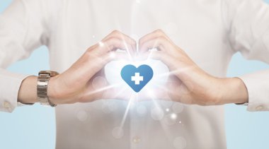 Eller mavi haçlı bir kalp yaratıyor.