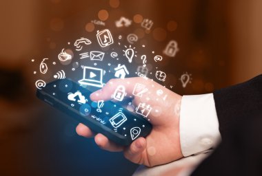 Medya simgeleri ve sembolleriyle el ele tutuşan akıllı telefon 