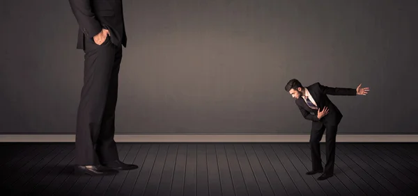 Little bussinesman in front of a giant boss legs concept — Stock Photo, Image