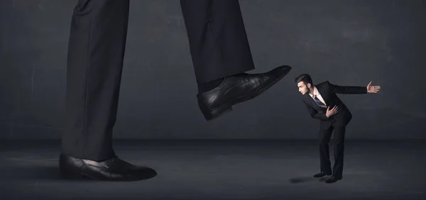 Gigante pessoa pisando em um pequeno conceito de homem de negócios — Fotografia de Stock