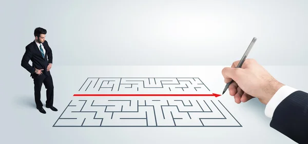Affärsman tittar på handritning lösning för labyrint — Stockfoto