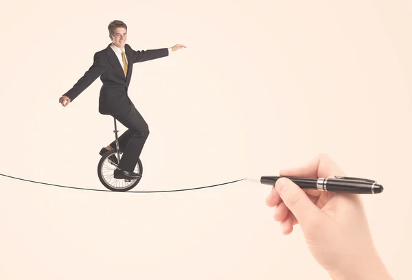 Businessman riding monocycle on a rope drawn by hand — Stock Photo, Image