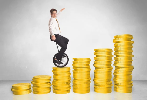 Business man riding monocycle up on coin graph — Stock Photo, Image