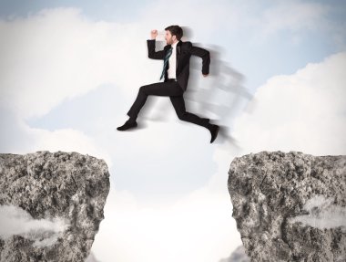 Komik iş adamı kayaların üzerinden atlıyor.