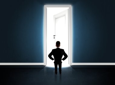 Büyük parlak kapıyı açan bir iş adamı.