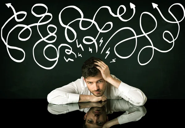 Depressed businessman sitting under drawn direction lines — Stock Photo, Image