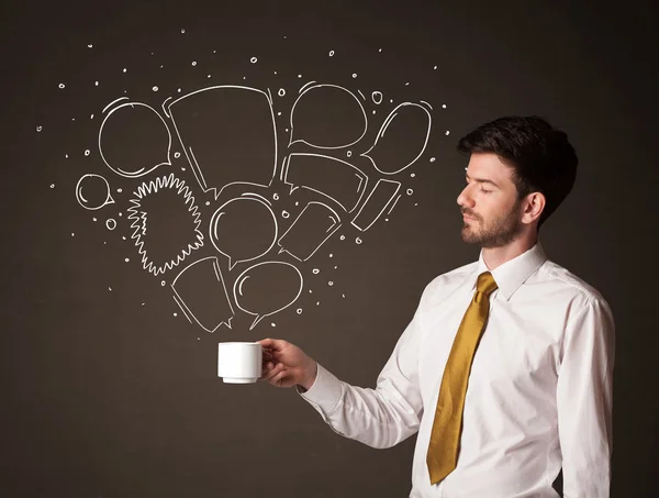 Businessman holding a white cup with speech bubbles — Stock Photo, Image