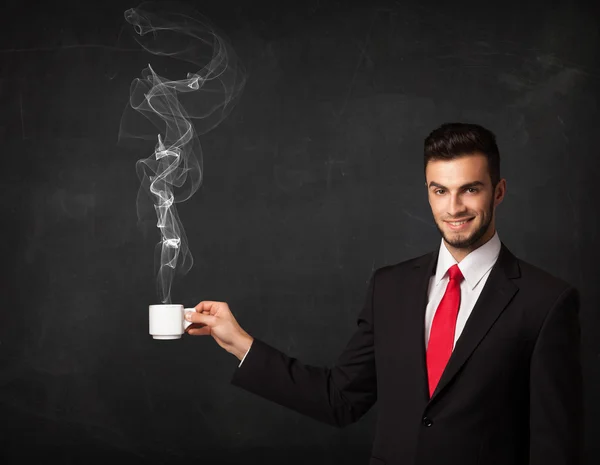 Affärsman som håller en vit ångande kopp — Stockfoto