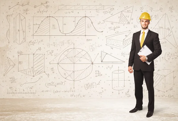 Handsome engineer calculating with hand drawn background — Stock Photo, Image