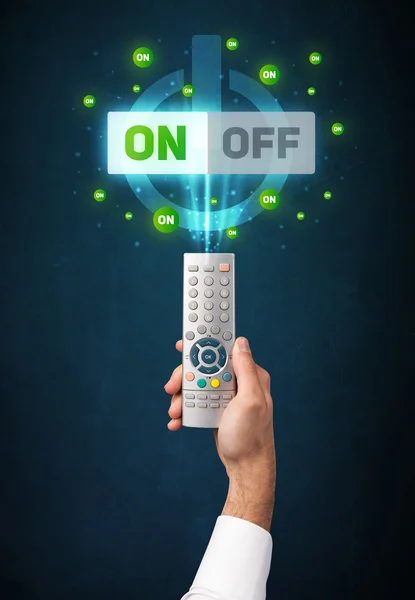 Hand with remote control and on-off signals — Stock Photo, Image
