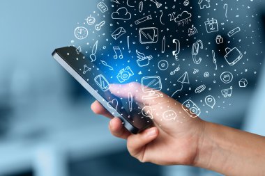 Elle çizilmiş medya simgeleri ve sembolleri ile akıllı telefonu tutmak